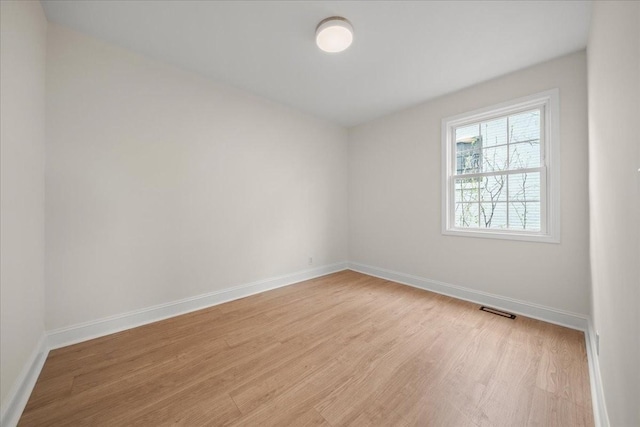 empty room with visible vents, baseboards, and light wood-type flooring