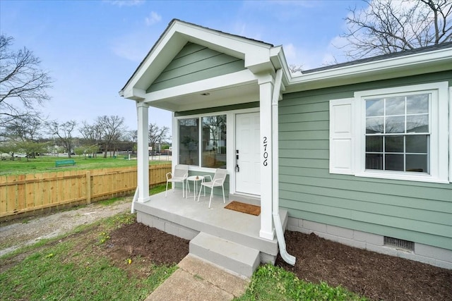 doorway to property with fence and crawl space