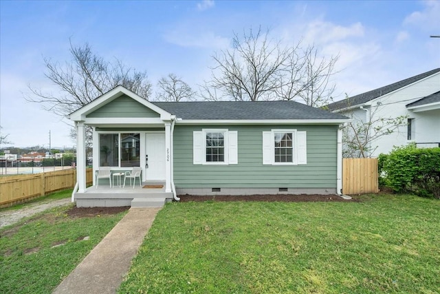 view of front facade featuring crawl space, roof with shingles, a front yard, and fence