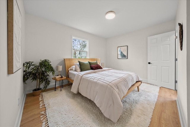 bedroom with light wood finished floors and baseboards