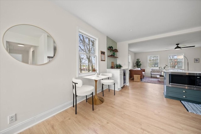corridor featuring light wood-style flooring and baseboards