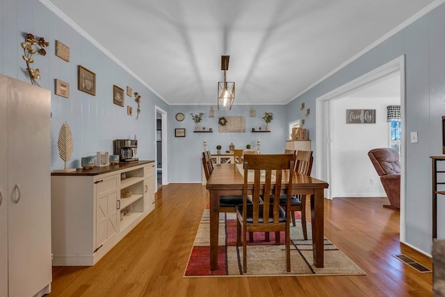 dining space featuring crown molding, visible vents, and light wood-type flooring