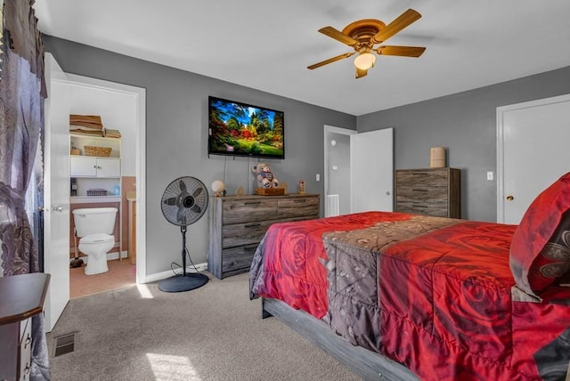 carpeted bedroom featuring ceiling fan, visible vents, baseboards, and ensuite bathroom