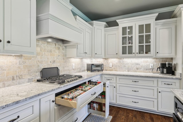 2042 Imagine Cir, Spring Hill, TN 37174 - kitchen with custom range hood, stainless steel gas stovetop, white cabinetry, backsplash, and crown molding