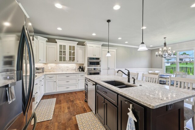 2042 Imagine Cir, Spring Hill, TN 37174 - kitchen with stainless steel appliances, a sink, ornamental molding, an island with sink, and white cabinetry