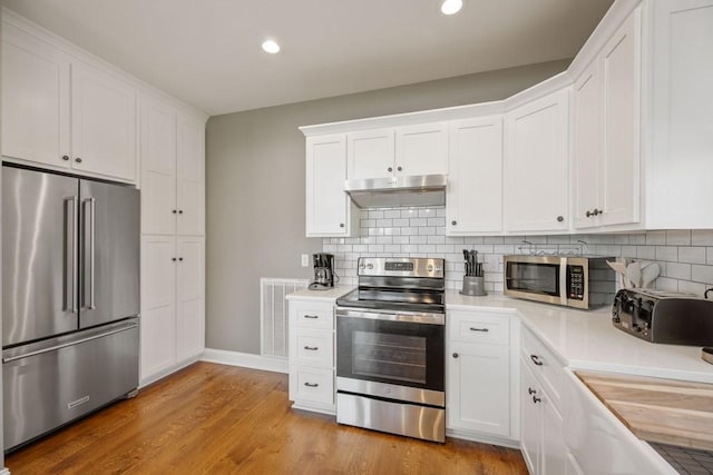 kitchen with visible vents, light countertops, under cabinet range hood, and stainless steel appliances