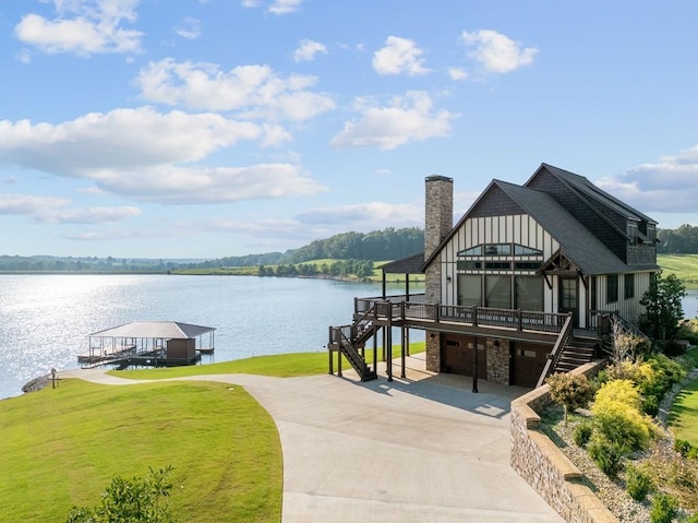 view of dock featuring a water view, a yard, and stairway