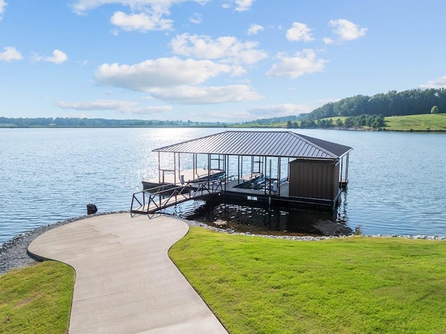 dock area with a water view, a lawn, and boat lift