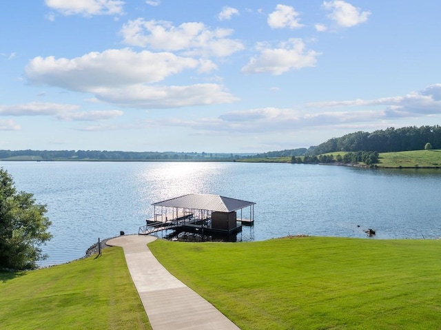 dock area with a water view, a yard, and boat lift