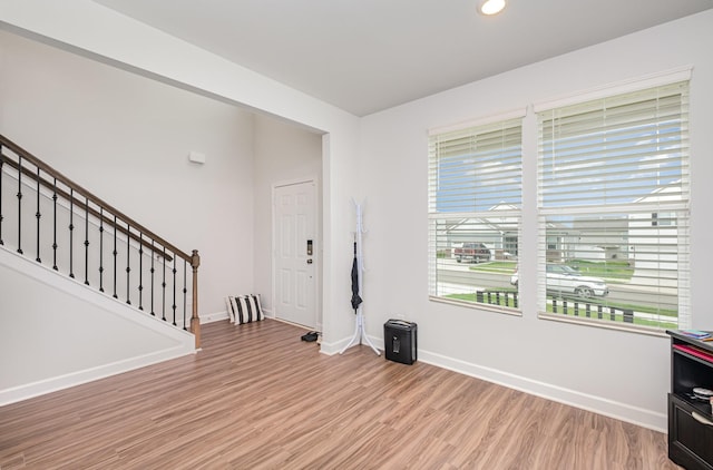 entryway featuring recessed lighting, baseboards, light wood finished floors, and stairway