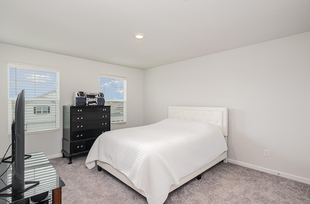 bedroom featuring light colored carpet and baseboards