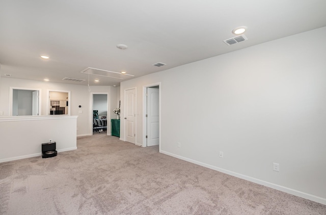 unfurnished room with attic access, carpet flooring, visible vents, and recessed lighting
