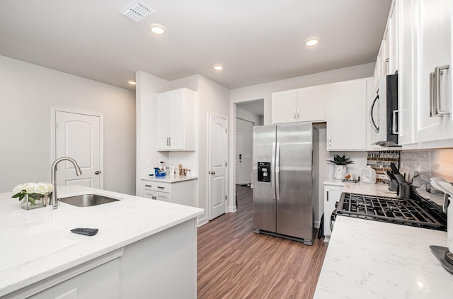 kitchen featuring appliances with stainless steel finishes, a sink, white cabinetry, and visible vents