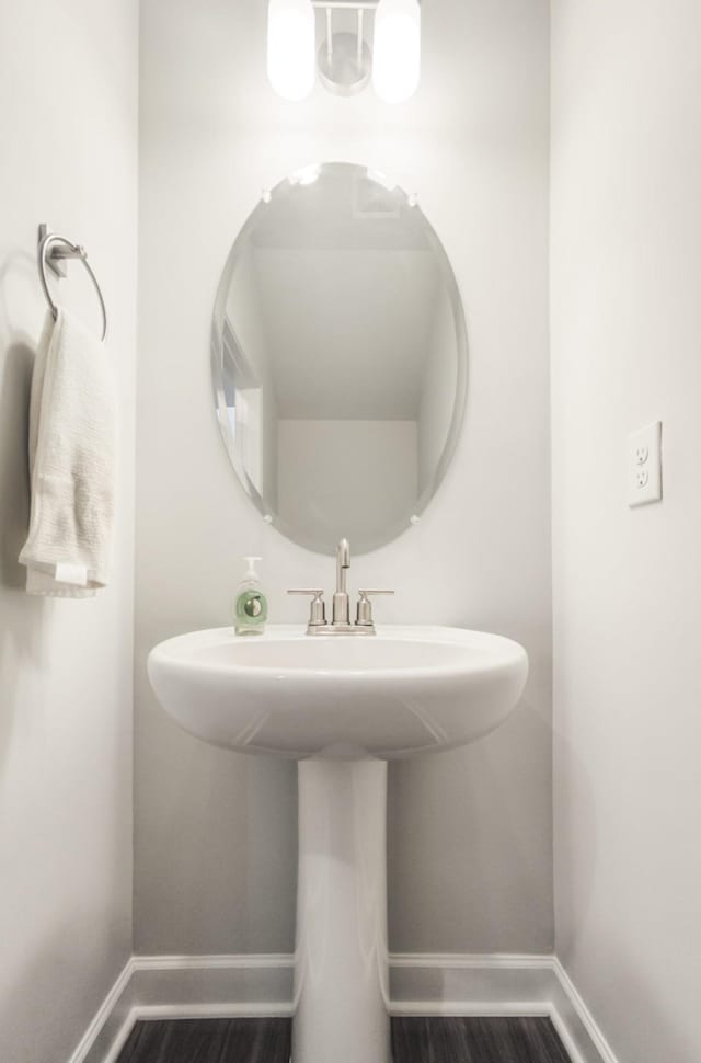 bathroom with wood finished floors and baseboards