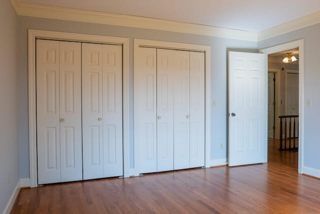 1601 Harvie Mills Rd W, Cookeville, TN 38501 - unfurnished bedroom with crown molding, wood finished floors, baseboards, and multiple closets