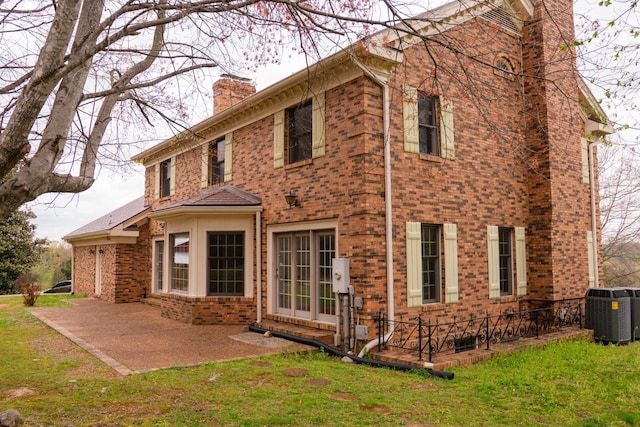 1601 Harvie Mills Rd W, Cookeville, TN 38501 - back of property featuring central AC, a yard, a patio, brick siding, and a chimney