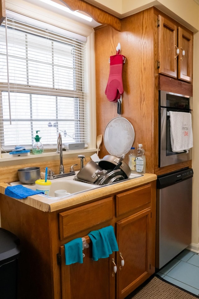 1601 Harvie Mills Rd W, Cookeville, TN 38501 - kitchen with stainless steel appliances, tile patterned floors, brown cabinets, and light countertops