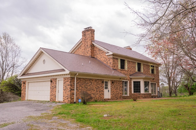 1601 Harvie Mills Rd W, Cookeville, TN 38501 - view of front of property featuring a front yard, an attached garage, a chimney, brick siding, and driveway