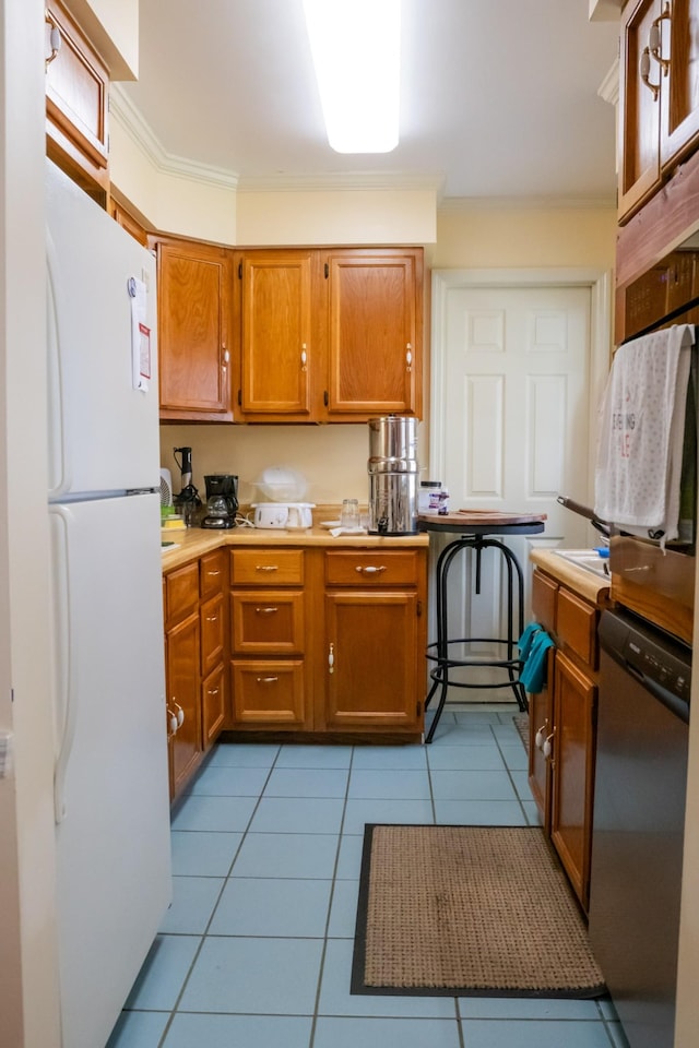 1601 Harvie Mills Rd W, Cookeville, TN 38501 - kitchen featuring light countertops, freestanding refrigerator, brown cabinetry, stainless steel dishwasher, and light tile patterned flooring