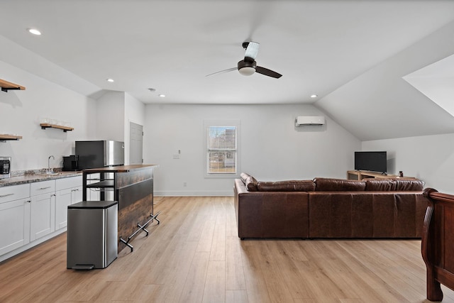 living room with an AC wall unit, ceiling fan, light wood-type flooring, recessed lighting, and vaulted ceiling