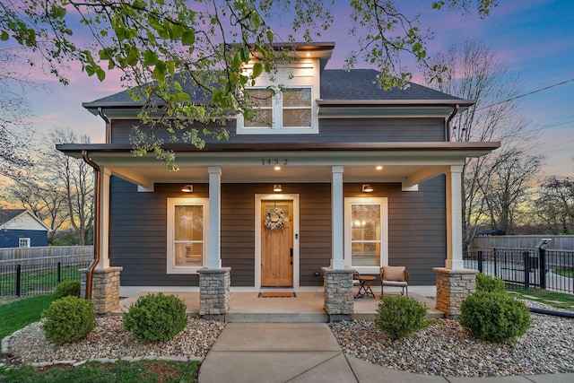 view of front of house with a porch and fence