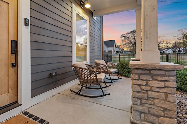 patio terrace at dusk with a porch and fence