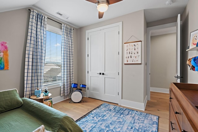 bedroom featuring a closet, light wood-type flooring, baseboards, visible vents, and ceiling fan