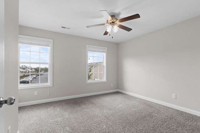 unfurnished room with ceiling fan, visible vents, carpet floors, and a healthy amount of sunlight