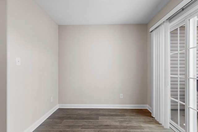 empty room with baseboards and wood finished floors