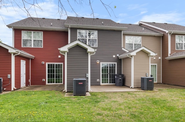 back of property with central AC, a lawn, and a patio area