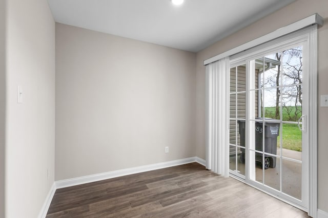 unfurnished room with baseboards and wood finished floors