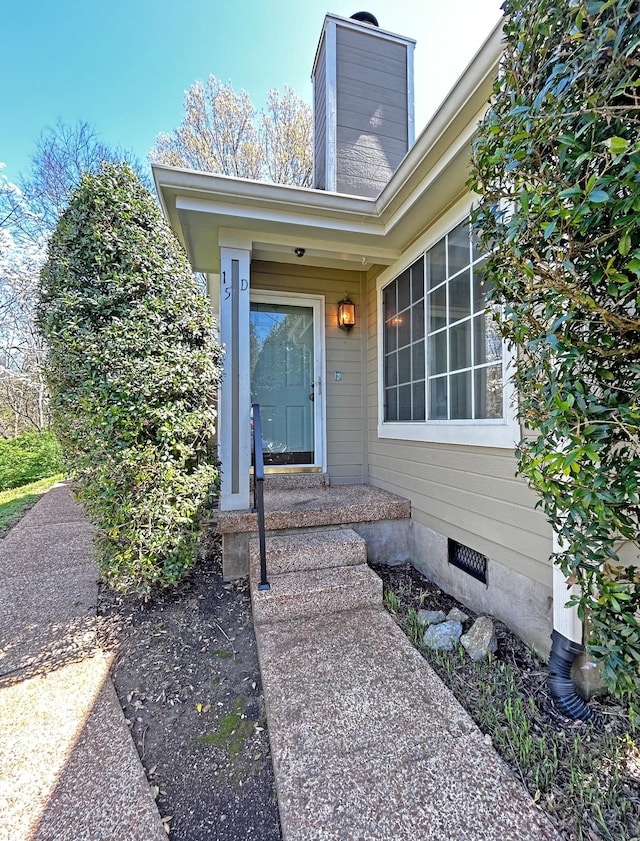 entrance to property featuring crawl space and a chimney