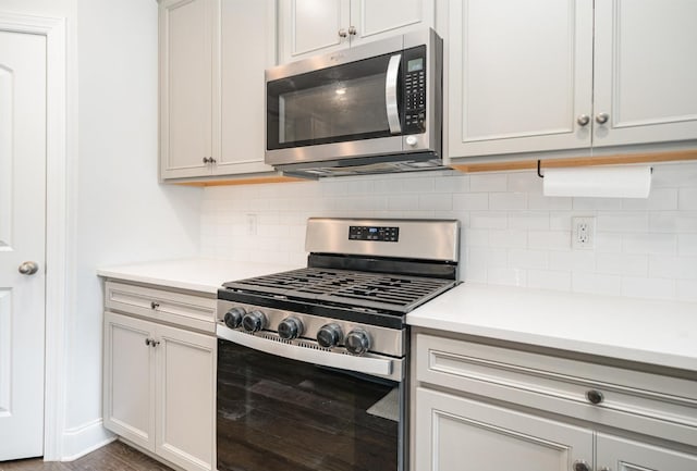 kitchen featuring light countertops, appliances with stainless steel finishes, and decorative backsplash