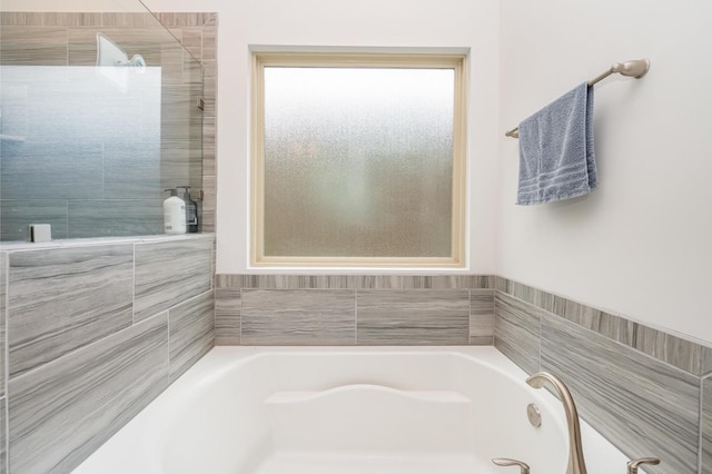 bathroom with a tile shower and a garden tub