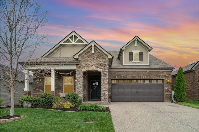 view of front of property featuring brick siding, a lawn, a garage, and driveway