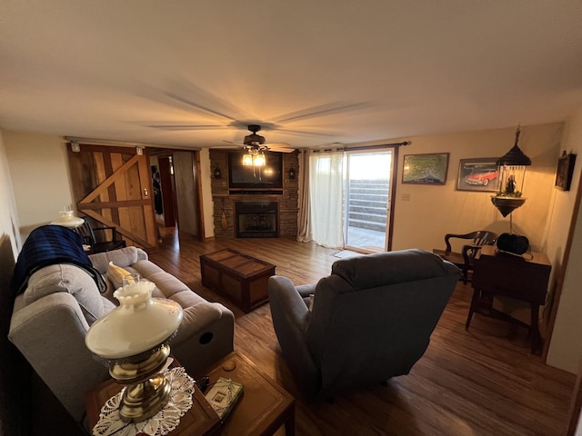 living room featuring wood finished floors, ceiling fan, and a fireplace