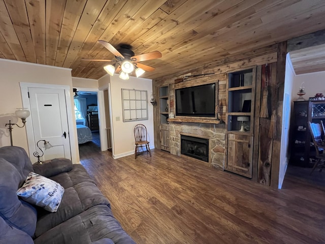 living room with built in shelves, ceiling fan, a fireplace, wood finished floors, and baseboards