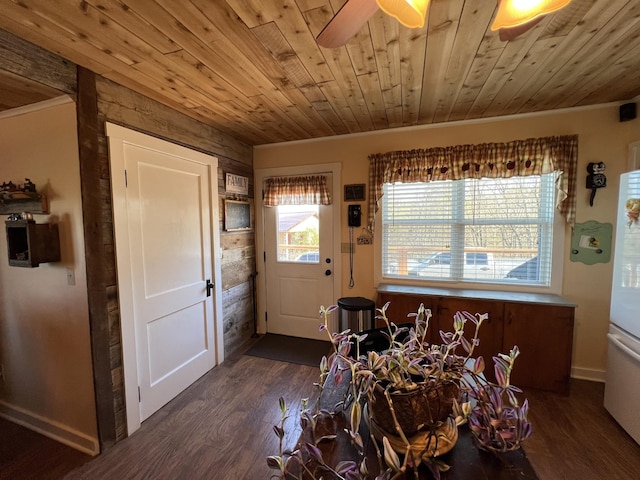 dining room featuring wooden ceiling, wood finished floors, ornamental molding, baseboards, and ceiling fan