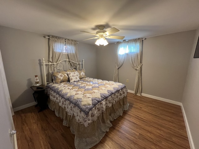 bedroom featuring wood finished floors, baseboards, and multiple windows