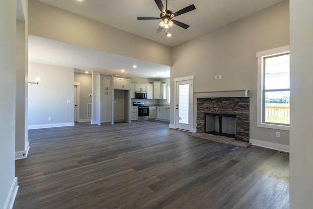 unfurnished living room with ceiling fan, baseboards, dark wood-style floors, and a fireplace
