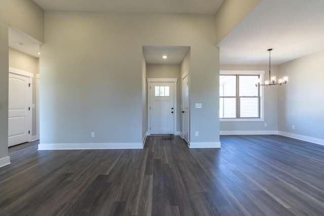 entrance foyer with a chandelier, baseboards, and dark wood-style floors