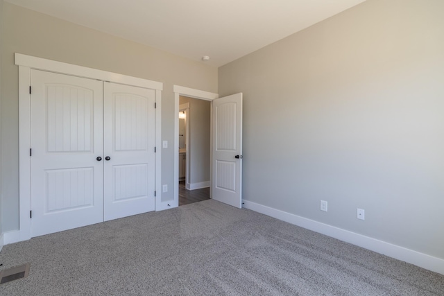 unfurnished bedroom featuring a closet, baseboards, carpet flooring, and visible vents