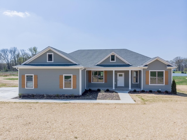 view of front of property featuring a porch and roof with shingles