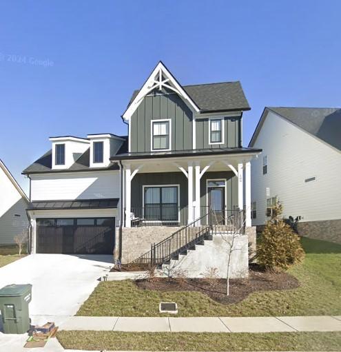 view of front of house with a porch, board and batten siding, a garage, and driveway