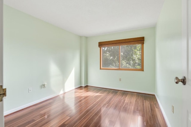 unfurnished room with wood finished floors and baseboards