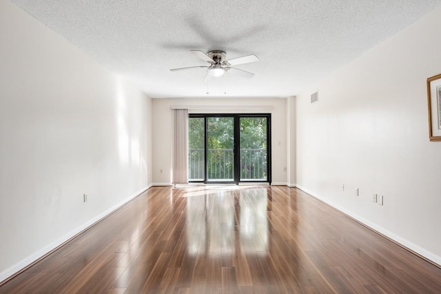 unfurnished room featuring a textured ceiling, wood finished floors, ceiling fan, and visible vents
