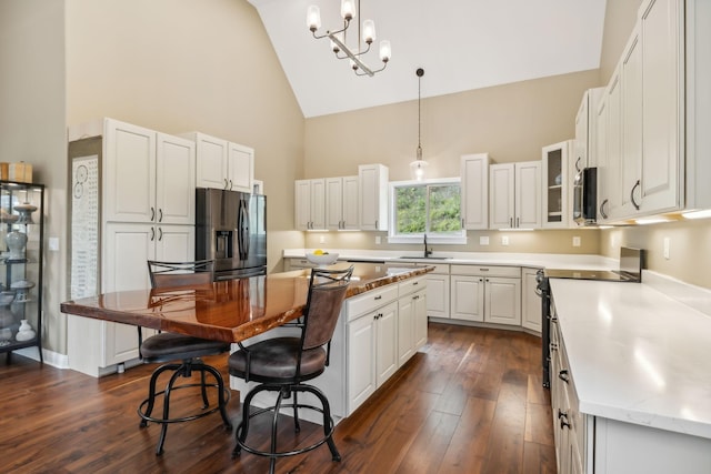 kitchen with white cabinetry, a breakfast bar, a kitchen island, a sink, and stainless steel appliances