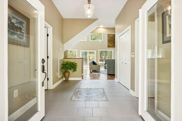 tiled foyer entrance with baseboards and visible vents