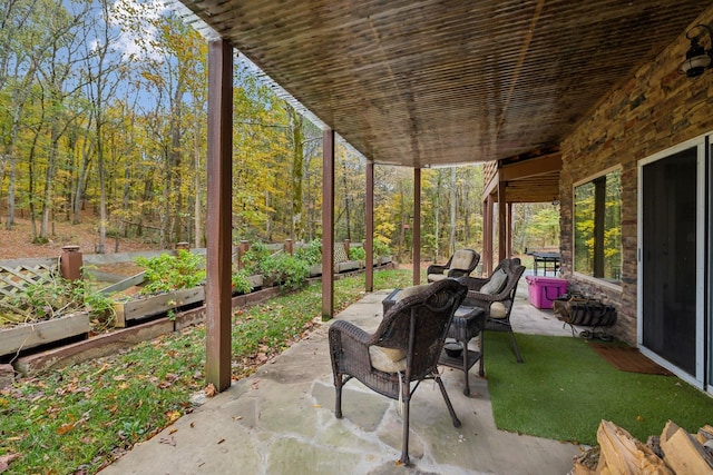 view of patio / terrace featuring a garden and a view of trees