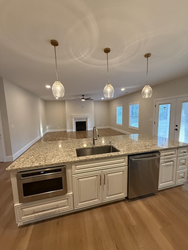 1168 N Franklin Ave, Cookeville, TN 38501 - kitchen featuring appliances with stainless steel finishes, a sink, wood finished floors, open floor plan, and light stone counters